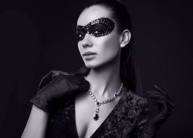 Güzel mor elbiseli zarif esmer kadının portresi, pullu maske ve siyah eldivenler çalıntı elmas kolye ile poz veriyor.