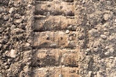 Açık arazi yolunda pist. Yerde tank izleri var..