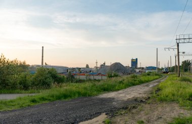 Demiryolu yakınında büyük bir çimento fabrikası. Borular, tanklar, kamyonlar, traktörler, ekipmanlar.