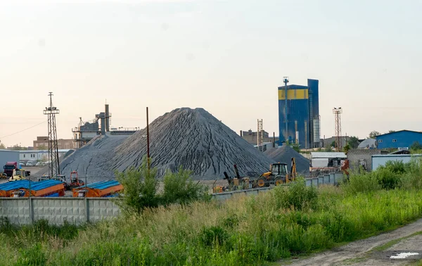 Demiryolu yakınında büyük bir çimento fabrikası. Borular, tanklar, kamyonlar, traktörler, ekipmanlar.