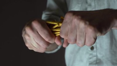 Kafkasyalı fırıncı tuzlu ekmek çubuklarını iki parçaya ayırır. Ekmek kırıntısına yakın çekim.