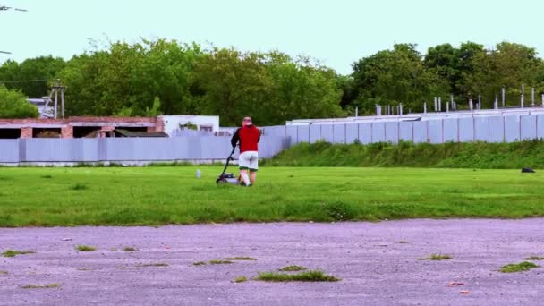 Male Handyman Mows Grass Lawn Mower Old Abandoned Stadium — Stock Video