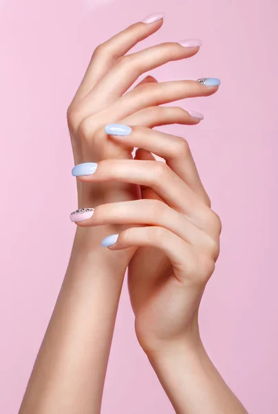 Hermosa manicura rosa y azul con cristales en la mano femenina. Primer plano . — Foto de Stock