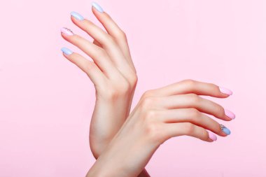Güzel pembe ve mavi manikür el üzerinde kristalleri ile. Yakın çekim.