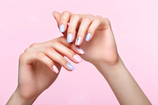 Manicure rosa e azul bonito com cristais na mão feminina. Close-up . — Fotografia de Stock