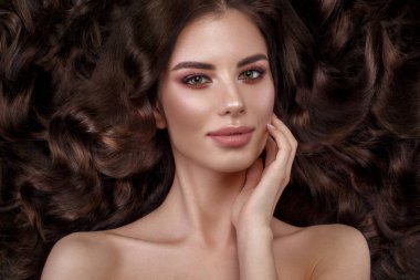 Güzel esmer model: bukleler, klasik makyaj ve dolgun dudaklar. Güzellik yüz.