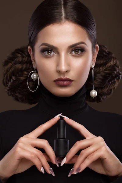 Jolie fille, coiffure insolite, maquillage lumineux, lèvres rouges et design de manucure avec un pot de vernis à ongles dans ses mains. Un beau visage. Ongles d'art . — Photo