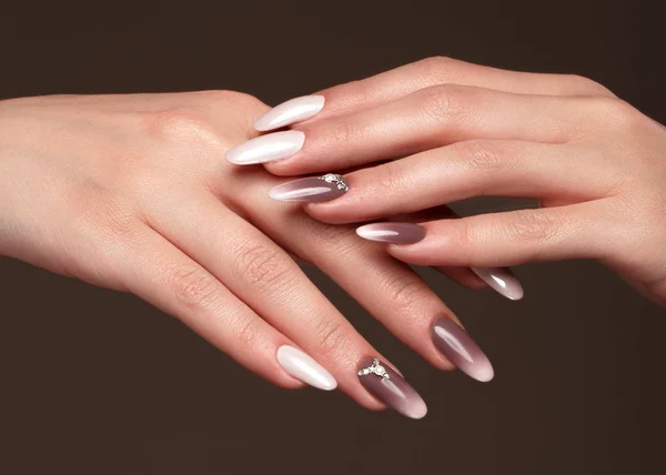 Beautiful classic manicure with crystals on female hand. Close-up.