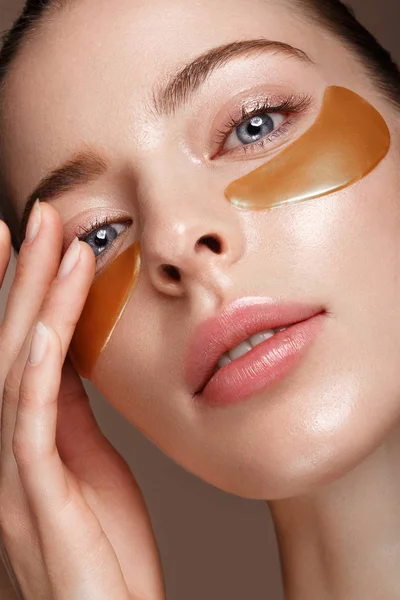 Güzel taze kız gözlerinin altında kozmetik yamalar ile mükemmel cilt ve doğal makyaj. Güzellik.