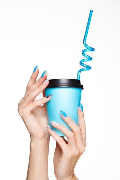 Прекрасный летний синий маникюр с кристаллами на женской руке. Крупный план
.