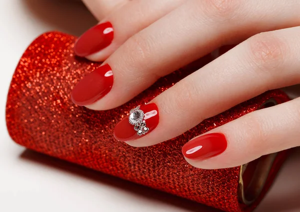 Manicura vermelha festiva brilhante em mãos femininas. Desenho de unhas — Fotografia de Stock