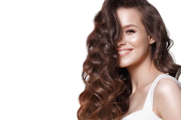 Mooi jong meisje in witte jurk met natuurlijke make-up, haren krullen en glimlach. Het gezicht van de schoonheid. Foto genomen in de studio. — Stockfoto