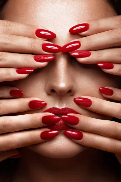 Bella ragazza con un trucco classico e unghie rosse. Design della manicure. Bellezza viso . — Foto Stock