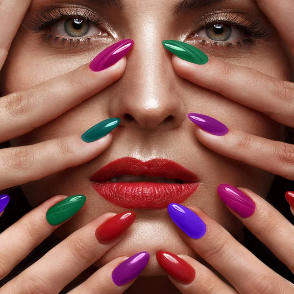 Menina bonita com uma maquiagem clássica e unhas multicoloridas. Design de manicure. Cara de beleza . — Fotografia de Stock