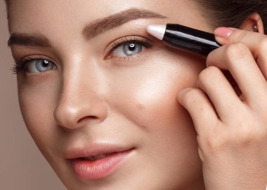 Doğal çıplak makyaj ve fosforlu kalem kalem ile güzel genç kız. Güzellik.