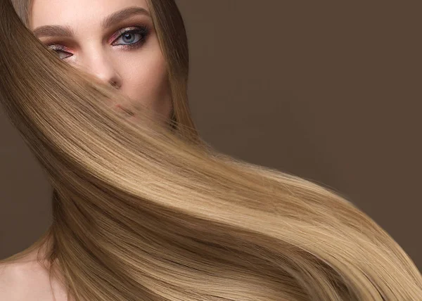 Schöne blonde Mädchen mit einem perfekt glatten Haar, klassisches Make-up. Schönheit Gesicht — Stockfoto