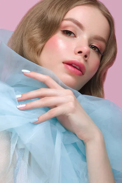 Vacker flicka med ljus make-up och mild manikyr i blå kläder. Skönhet ansikte. Design naglar. — Stockfoto