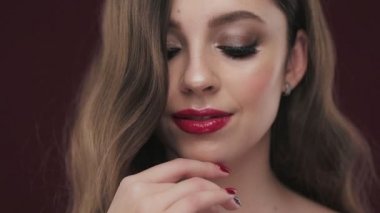 Güzel esmer modeli ile bukleler, klasik makyaj ve seksi kırmızı dudaklar.