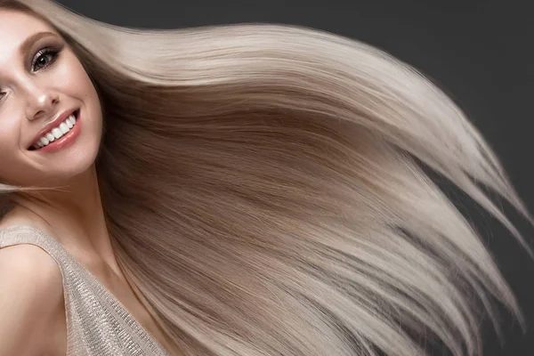 Schöne blonde Mädchen in Bewegung mit einem perfekt glatten Haar und klassischem Make-up. Schönheit Gesicht. — Stockfoto