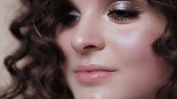 Beautiful brunette girl with a perfectly curly hair, and classic make-up posing in the studio. Beauty face. — Stock Video