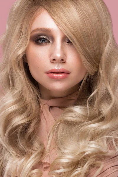 Belle fille blonde aux cheveux bouclés, ressemble à une poupée, avec un maquillage glamour en vêtements roses. Beauté visage . — Photo