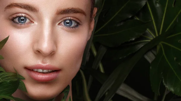 Belle fille fraîche avec une peau parfaite, maquillage naturel et feuilles vertes. Beauté visage . — Photo