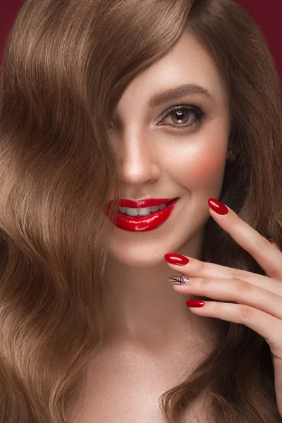 Hermosa chica con un maquillaje clásico, rizos de pelo y uñas rojas. Diseño de manicura. Cara de belleza . — Foto de Stock