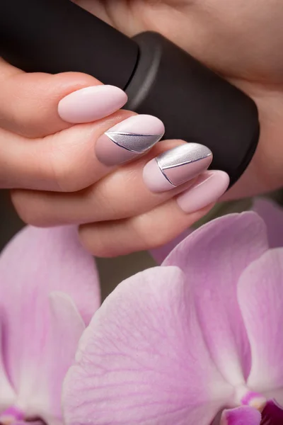 Manicura púrpura ordenada en manos femeninas sobre fondo de flores. Diseño de uñas — Foto de Stock