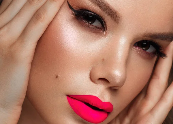 Hermosa mujer joven con maquillaje brillante y labios de color rosa neón. Cara de belleza. Foto tomada en el estudio —  Fotos de Stock