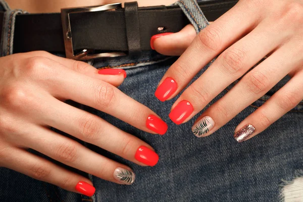 Manicura de color rojo neón brillante en las manos femeninas en el fondo de los vaqueros. Diseño de uñas. Belleza manos . — Foto de Stock