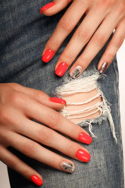 Felle neon rode manicure op vrouwelijke handen op de achtergrond van jeans. Nagel ontwerp. Schoonheid handen. — Stockfoto