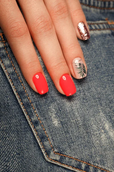 Manicura de color rojo neón brillante en las manos femeninas en el fondo de los vaqueros. Diseño de uñas. Belleza manos . — Foto de Stock