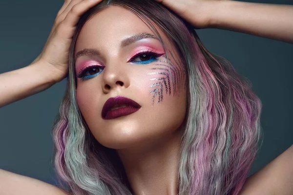 Mooi meisje met veelkleurig haar en creatieve make-up en kapsel. Schoonheidsgezicht. — Stockfoto