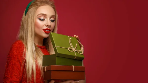 Gyönyörű szőke lány egy új év képet doboz ajándékok kezében. Szépség arc ünnepi smink. — Stock Fotó