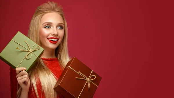 Hermosa chica rubia en una imagen de Año Nuevo con cajas de regalos en las manos. Cara de belleza con maquillaje festivo . —  Fotos de Stock