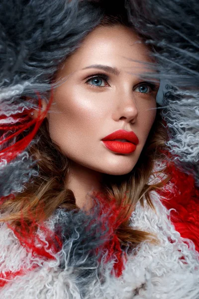 Schöne Frau mit klassischem Urlaubs-Make-up, roten Lippen, Locken im bunten Lamamantel. Schönheitsgesicht. — Stockfoto