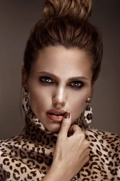 Mulher sexy bonita em um casaco de leopardo e brincos, com maquiagem clássica e um penteado elegante. Cara de beleza . — Fotografia de Stock
