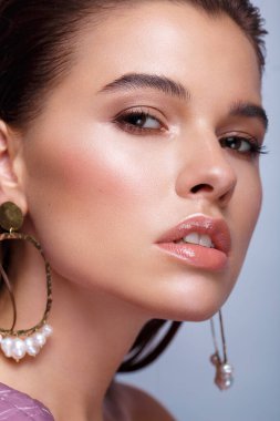 Klasik makyajlı, mor elbiseli, pürüzsüz saçlı güzel bir kız. Güzel surat..