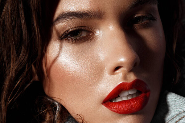Beautiful sexy girl with bright makeup, red lips, wet hair in a denim jacket. Beauty face.