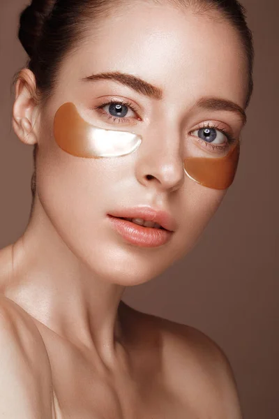 Beautiful fresh girl with cosmetic patches under eyes, perfect skin and natural make-up. Beauty face. — Stock Photo, Image