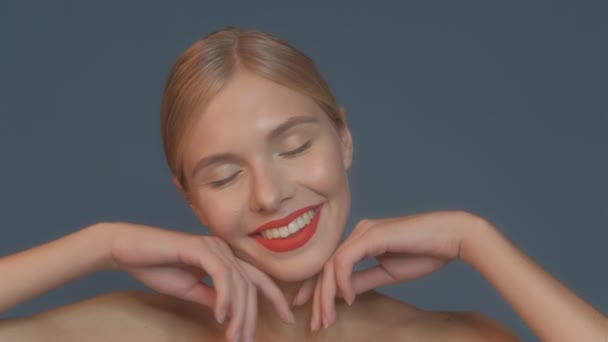 Mooi meisje met rode lippen en klassieke make-up poseren in de studio. Schoonheidsgezicht. — Stockvideo