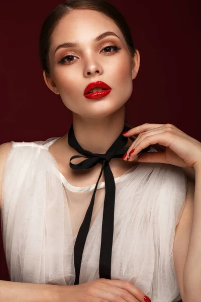 Piękna dziewczyna w białej sukience z klasycznym makijażem i czerwonym manicure. Piękna twarz. — Zdjęcie stockowe