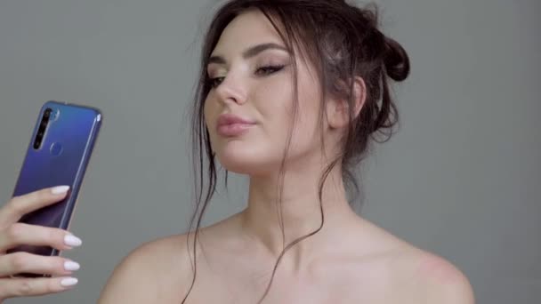 Schöne Mädchen mit klassischem Make-up posiert vor der Handykamera. — Stockvideo