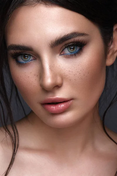 Gyönyörű lány fényes divatos smink, szeplők és kék szemek. Szépség arc. — Stock Fotó