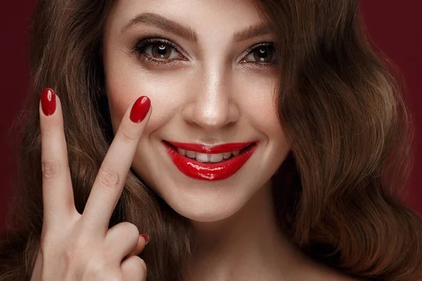 Bella ragazza con un trucco classico, riccioli capelli e unghie rosse. Design della manicure. Bellezza viso . — Foto Stock