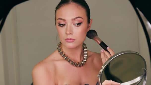 Dívka nanáší make-up před zrcadlo štětcem na prášek. Pózování před telefonní kamerou. — Stock video