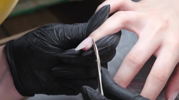 Mistr dělá hygienickou manikúru klientovi v nehtovém studiu. Řezání kůžiček nůžkami. — Stock video