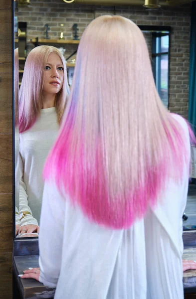 Beautiful blond girl with colored pink hair in a hairdressing salon. — Stock Photo, Image