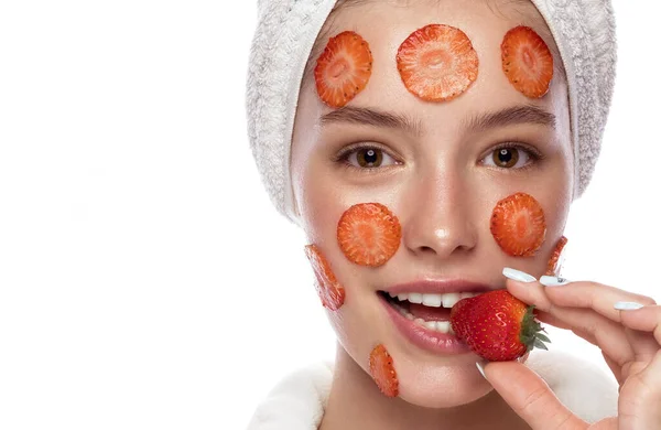 Gadis muda cantik dengan handuk putih dengan kulit segar bersih berpose di depan kamera dengan topeng Strawberry di wajah. Wajah cantik. Perawatan kulit. — Stok Foto