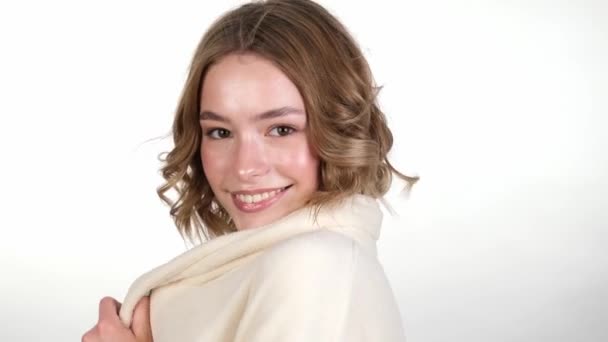 Mooi teder jong meisje in een witte huisbadjas met schone frisse huid poserend voor de camera. Schoonheidsgezicht. Huidverzorging. — Stockvideo